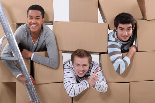 Movers carrying furniture through a central London flat access point