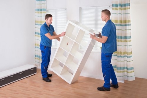 Moving team handling boxes and furniture in a Waterloo flat